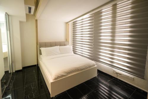 a small bed in a room with a window at D'Nova Hotel Bugis in Singapore