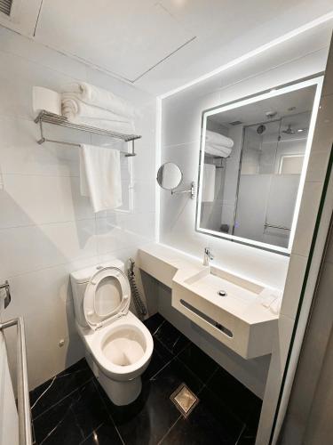 a bathroom with a toilet and a sink and a mirror at D'Nova Hotel Bugis in Singapore