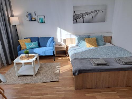 a bedroom with a bed and a blue couch at Adam apartmán in Košice