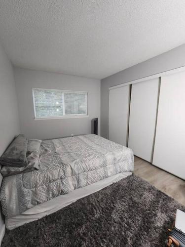 - une chambre avec un grand lit et une fenêtre dans l'établissement Apartment in Beaverton, à Beaverton