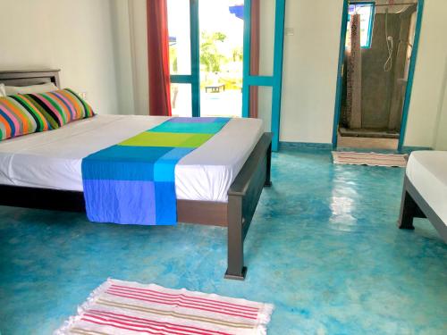 a bedroom with a bed and a blue floor at Seth Villa by Magampura Resorts in Tangalle