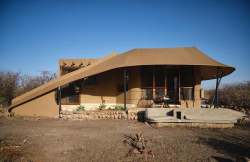 a house with a large roof on top of it at Surana Buffalo Springs in Buffalo Springs  National Reserve