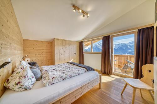 een slaapkamer met een bed en een groot raam bij Jogglanderhof - Wasserfall in Moso