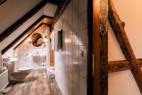une salle de bains mansardée avec lavabo et toilettes. dans l'établissement Hotel Einbecker Hof, à Einbeck