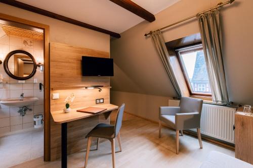 a room with a desk and chairs and a sink at Hotel Einbecker Hof in Einbeck