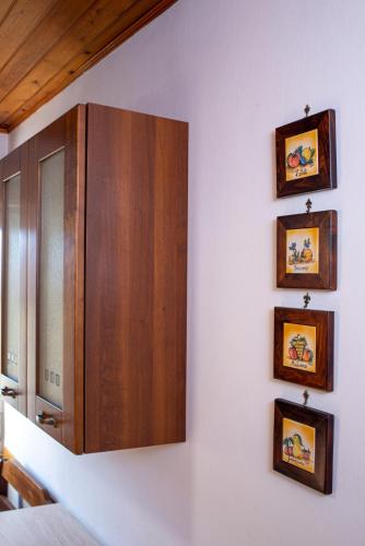 a kitchen with a wooden cabinet and pictures on the wall at Casa Verdi Colli in Montecastrilli