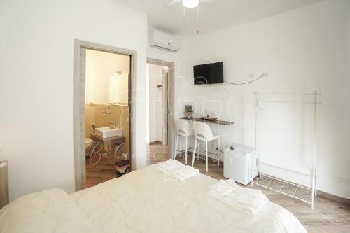 a white bedroom with a bed and a mirror at Balconi sul mare in Otranto