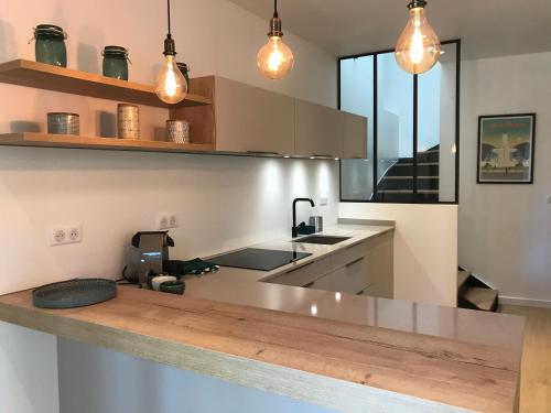 - une cuisine avec un évier et un comptoir éclairé dans l'établissement La Bastide - Le Grenache - Le Syrah au Domaine Chateau Henri Bonnaud, au Tholonet