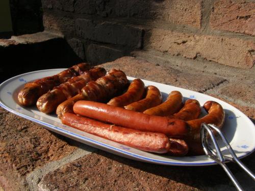a plate of hot dogs and sausages at Őrségi Tornácos Vendégfogadó in Felsőszenterzsébet