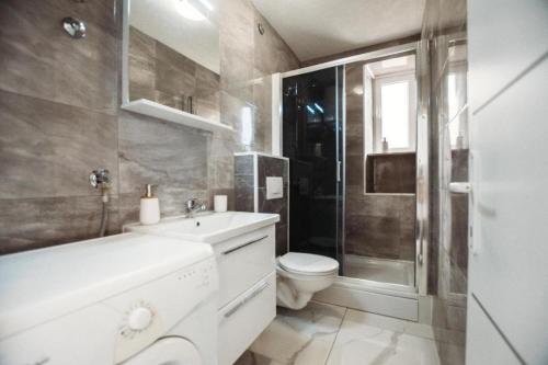 Un baño con inodoro, lavabo y ducha. en Apartment Essenza, en Zadar