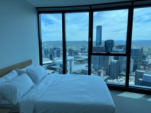 a bed in a room with a view of a city at Amazing views 60th level skytower 3 bedrooms in Brisbane