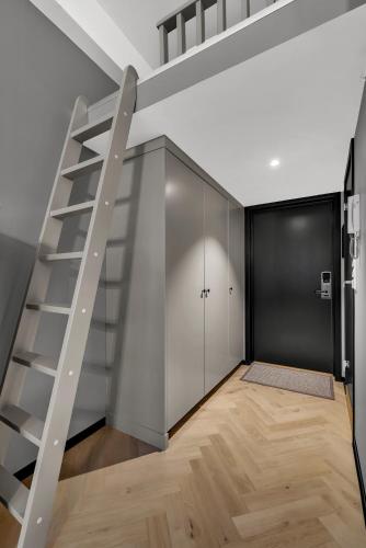 a loft bed with a staircase in a room at Origo Leilighetshotell in Drammen