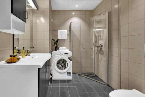 bagno con lavatrice e doccia di Origo Leilighetshotell a Drammen
