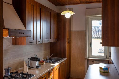 een keuken met houten kasten, een wastafel en een raam bij Casa Verdi Colli in Montecastrilli