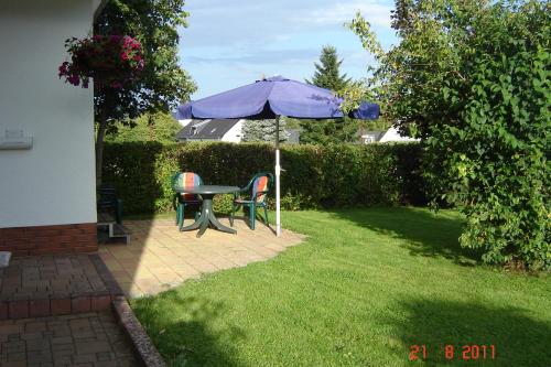 a patio with a table and an umbrella at Urlaub auf dem Bauernhof Marx in Kelberg