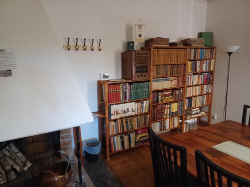 a living room with a table and bookshelves filled with books at Brukshotellet Skinnsberg in Skinnskatteberg