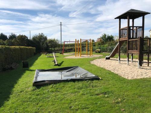 einen Spielplatz mit einer Plane auf dem Rasen in der Unterkunft Alte Schule Seinsfeld 