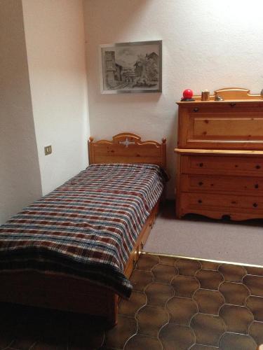 a bedroom with a bed and a dresser in a room at Appartamento Scoiattolo in Folgaria