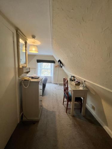 a room with a desk and a table with a chair at Greshornish House Hotel in Edinbane