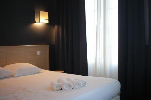 a hotel room with a bed with towels on it at Hotel Saint Louis in Brest