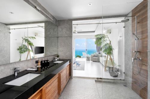 uma casa de banho com 2 lavatórios e uma cabina de duche em vidro. em Villa Melo em Chaweng Noi Beach