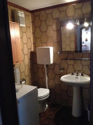 a bathroom with a toilet and a sink at Appartamento Scoiattolo in Folgaria