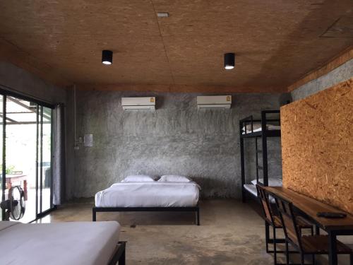 a bedroom with two bunk beds and a window at ชลลดา ริเวอร์ โฮมสเตย์ แก่งกระจาน in Ban Wang Malako
