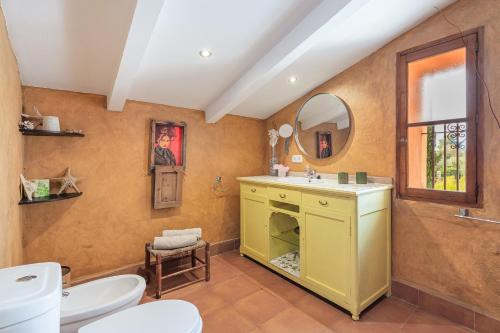 y baño con lavabo, aseo y espejo. en Villa Can Lloret, en Algaida