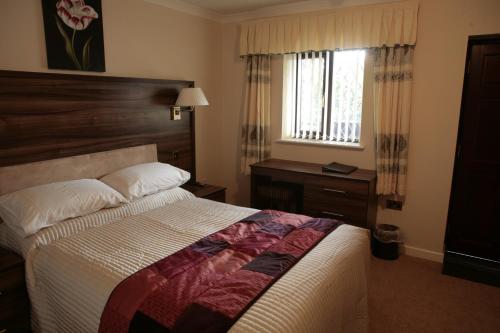 a hotel room with a bed and a window at The Plough Inn in Pocklington