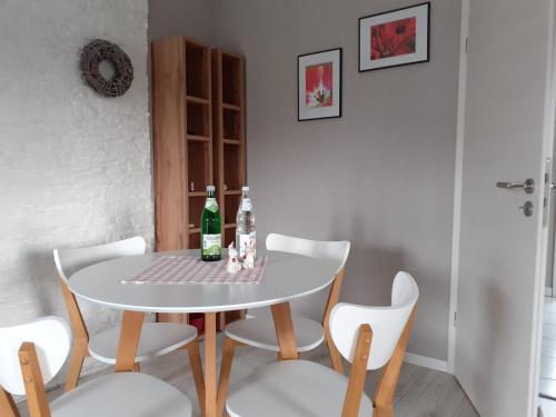 a dining room table with two bottles and chairs at Haus Mühlenbach in Mechernich