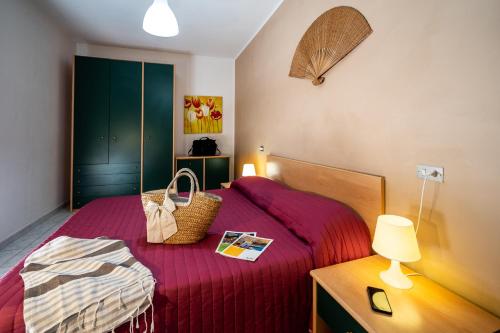 una camera da letto con un letto con una coperta rossa e una lampada di Vistamare a Silvi Marina