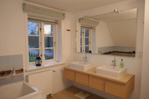 baño con 2 lavabos y espejo grande en Haus Sommerfrische, en Südstrand