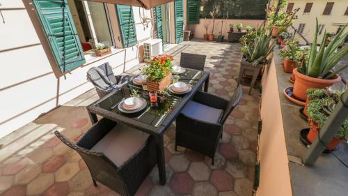 a table and chairs on a patio with plants at Sole, Terrazza, Centro città e Wi-Fi veloce! in Genova