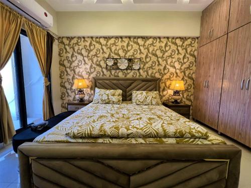 a bedroom with a large bed with two lamps at Sunnyvale Defense Executive Apartments 913 in Islamabad