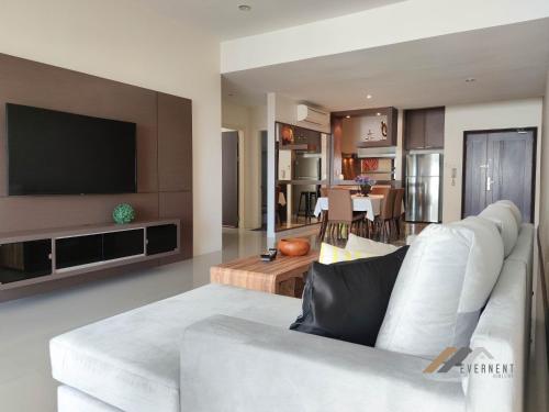 sala de estar con sofá blanco y TV en Evernent's Homestay @ The Wharf, en Miri