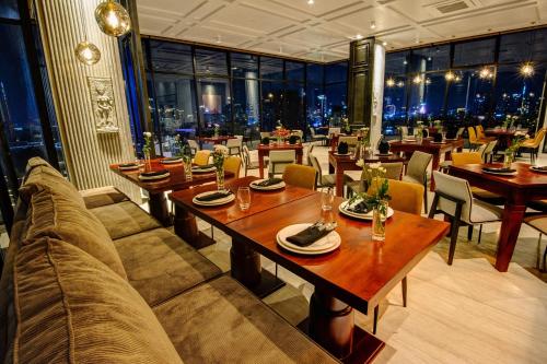 a restaurant with tables and chairs with a view of the city at GLOW PARK HOTEL Grand Royal Palace in Phnom Penh