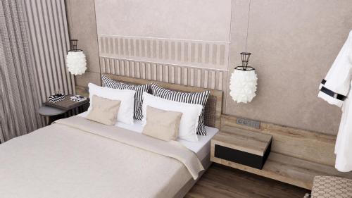 una camera da letto con letto, lenzuola e cuscini bianchi di Summer Beach Hotel a Georgioupoli