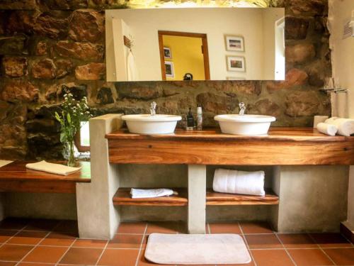 a bathroom with two sinks and a mirror at The Oil Mill Guesthouse in Swellendam