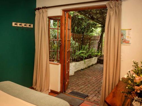 a room with a door open to a patio at The Oil Mill Guesthouse in Swellendam