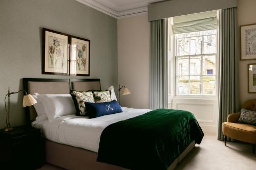 een slaapkamer met een groot bed en een raam bij Links Townhouse in St Andrews