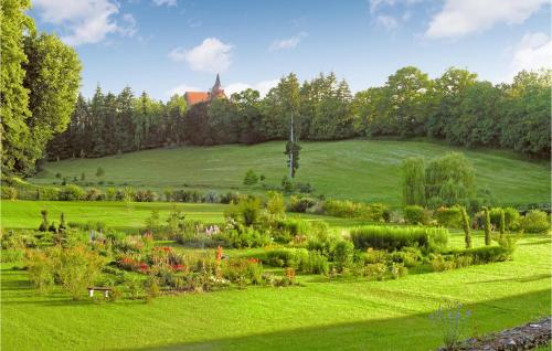a lush green field with a garden in the foreground at Nice Home In Conflans Sur Anille in Conflans-sur-Anille