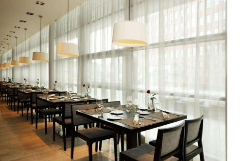 a long dining room with long tables and chairs at NH Amersfoort in Amersfoort