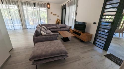 salon z kanapą i telewizorem w obiekcie Villa des 3 sables, CAPUCIN w mieście Étang-Salé les Bains