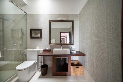 a bathroom with a sink and a toilet and a mirror at 42 Lighthouse Street in Galle