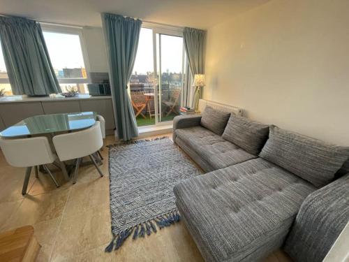 a living room with a couch and a table at Stylish flat next to Tower of London and SKD marina in London