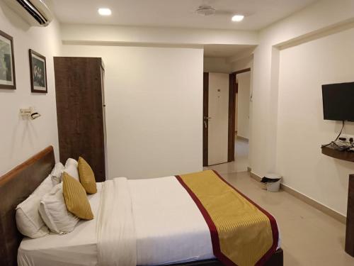 a bedroom with a bed and a television in it at Boshan Hotels in Mapusa