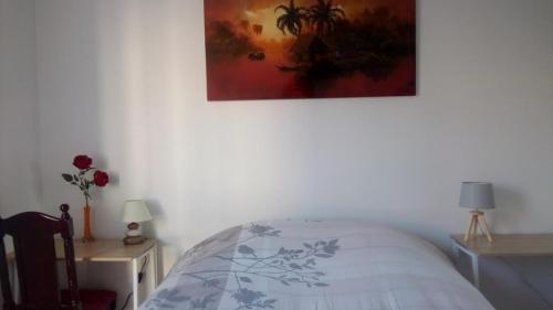a bedroom with a bed and a painting on the wall at VUE EXCEPTIONNELLE SUR LE LAC in Créteil