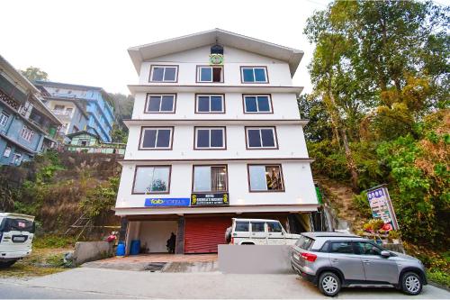 ein weißes Gebäude mit einem davor geparkt in der Unterkunft FabHotel The Grunge in Gangtok