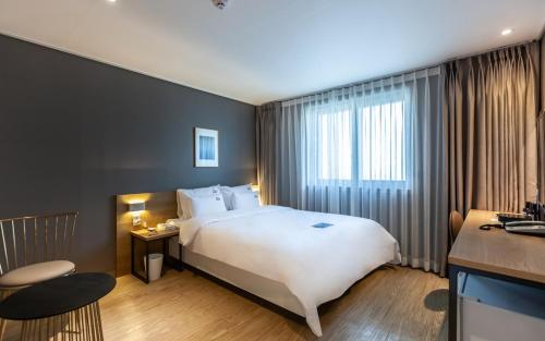 a hotel room with a large bed and a television at YAJA Hotel Tongyeong Ferry Terminal Branch in Tongyeong