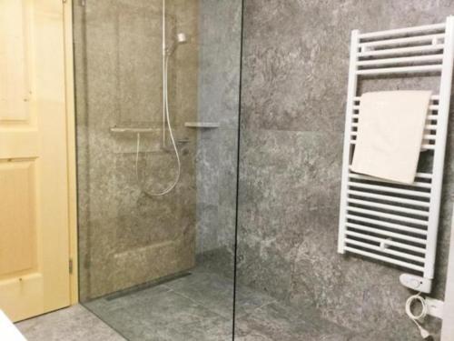 baño con ducha y puerta de cristal en Grosszügige Komfort FEWO - ENGADIN HOLIDAYS, en Guarda